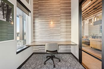 A room with a chair and a table with a window.